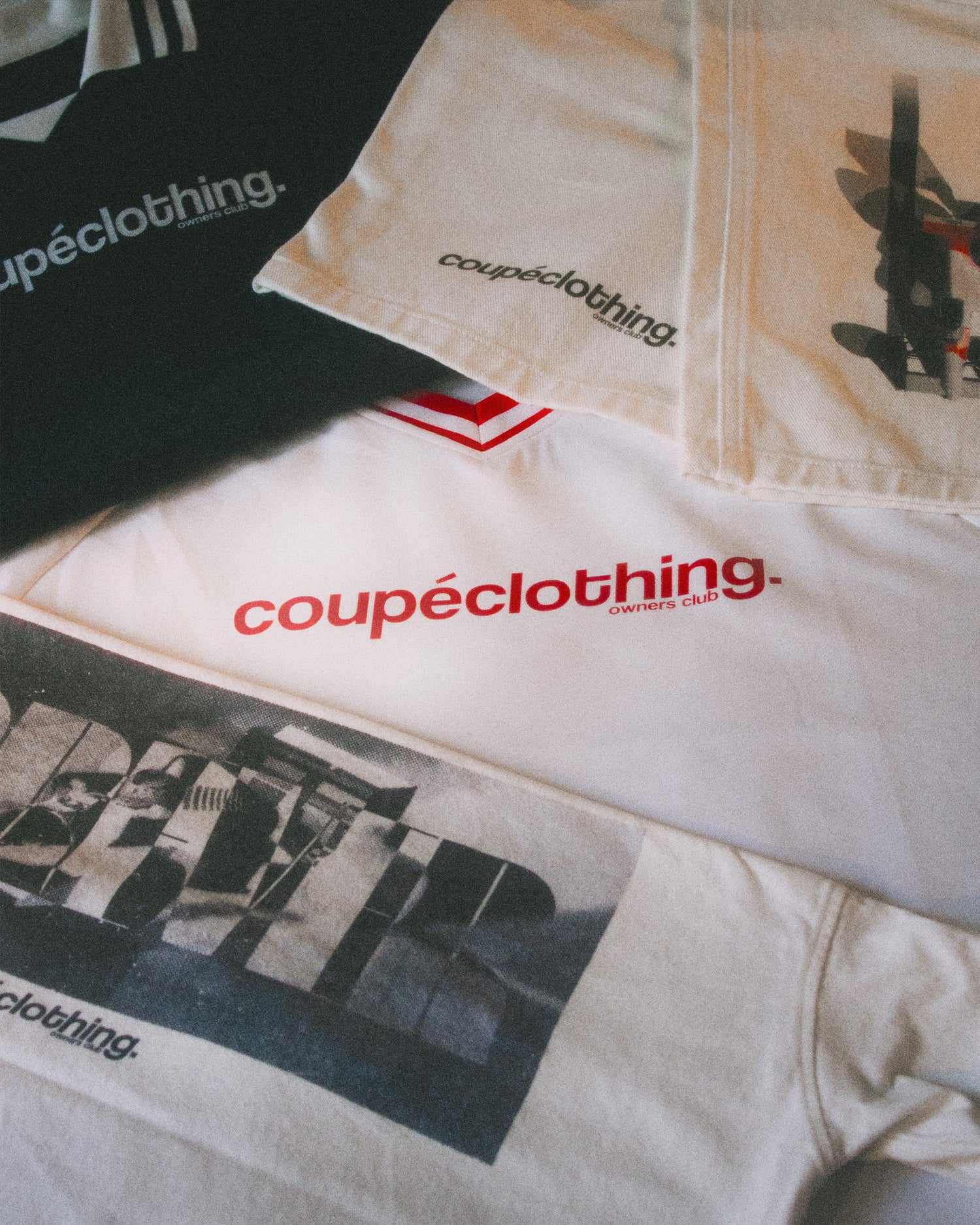 White jersey with red 'coupeclothing' logo amongst other clothing items.
